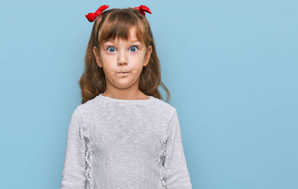 Petite fille caucasienne enfant portant des vêtements décontractés faisant visage de poisson avec des lèvres, geste fou et comique. expression drôle.  - Photo, image