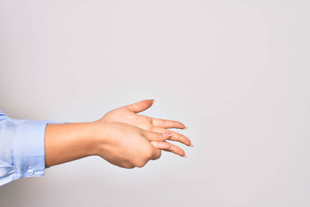 Mujer joven caucásica limpiando manos usando alcohol líquido sobre fondo blanco aislado - Foto, imagen
