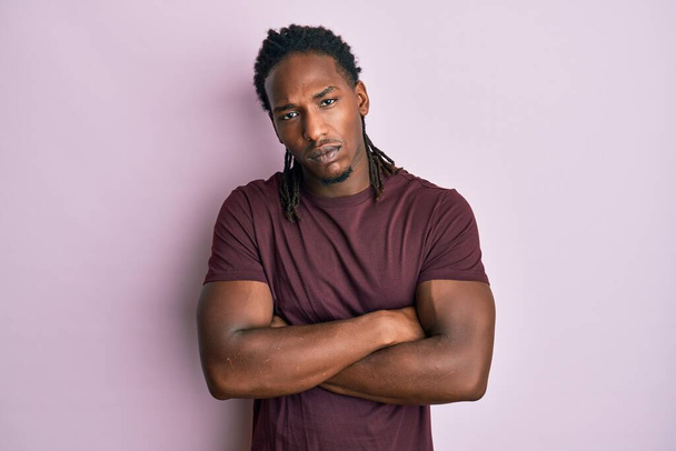 African american man with braids wearing casual clothes skeptic and nervous, disapproving expression on face with crossed arms. negative person.  - Photo, Image