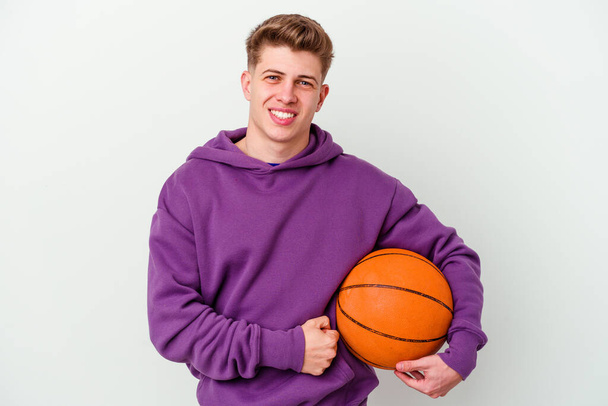 Giovane uomo caucasico giocare a basket isolato sfondo ridere e divertirsi. - Foto, immagini