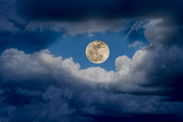 Wielki super księżyc wspaniale świeci z białymi chmurami na niebie w nocy, tło natury. - Zdjęcie, obraz