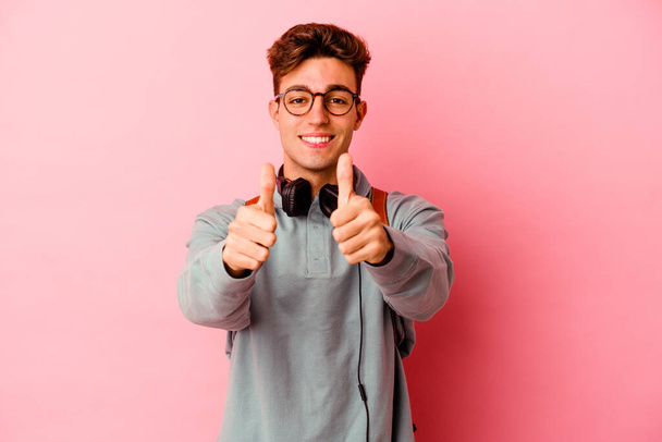 Mladý student muž izolované na růžovém pozadí s palci nahoru, jásot o něčem, podpora a respekt koncepce. - Fotografie, Obrázek