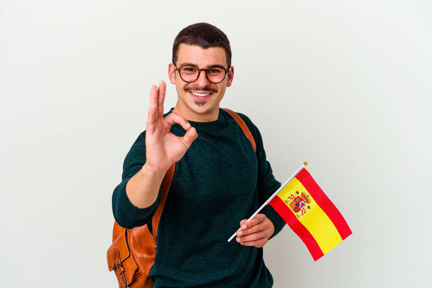 Jonge blanke man studeren Engels geïsoleerd op witte achtergrond vrolijk en zelfverzekerd tonen ok gebaar. - Foto, afbeelding