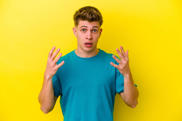 Young caucasian man isolated on yellow background showing number ten with hands. - Photo, Image