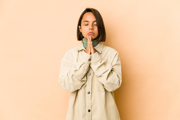 Młoda Latynoska kobieta odizolowana modląca się, okazująca oddanie, religijna osoba poszukująca boskiej inspiracji. - Zdjęcie, obraz