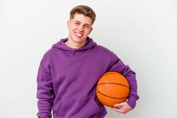 joven caucásico hombre jugando baloncesto aislado fondo feliz, sonriente y alegre. - Foto, Imagen