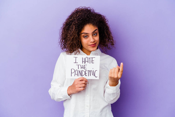Fiatal afro-amerikai nő a kezében Gyűlölöm a pandémiás plakátot, lila alapon, ujjal mutogatva rád, mintha a meghívó közelebb jönne.. - Fotó, kép