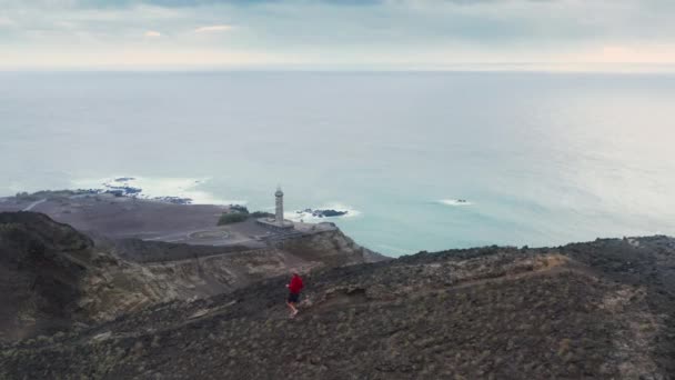 Άνθρωπος τζόκινγκ κάτω από ορεινό μονοπάτι του ηφαιστείου Capelinhos, Νησί Faial, Αζόρες - Πλάνα, βίντεο
