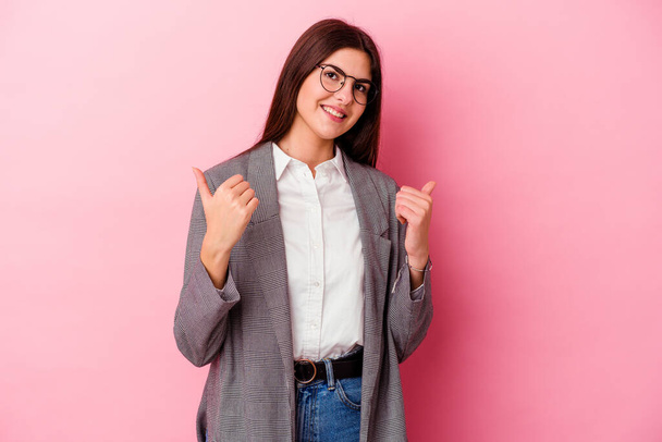 Νεαρή καυκάσια επιχειρηματίας απομονωμένη σε ροζ φόντο υψώνοντας τους αντίχειρες, χαμογελώντας και έχοντας αυτοπεποίθηση. - Φωτογραφία, εικόνα