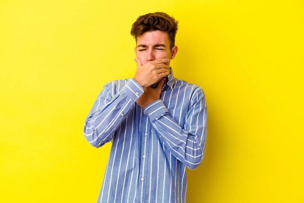 Jonge blanke man geïsoleerd op gele achtergrond lijdt pijn in de keel als gevolg van een virus of infectie. - Foto, afbeelding
