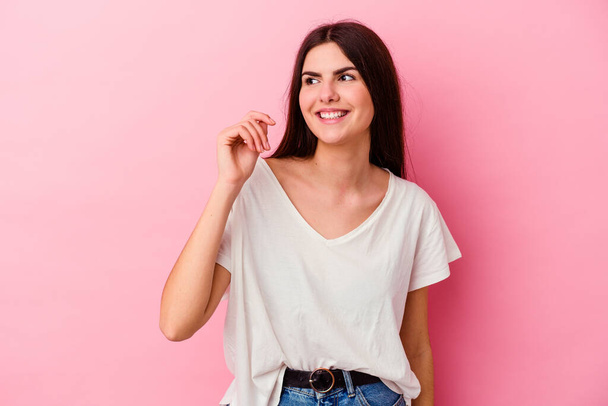 Young caucasian woman isolated on pink background laughing about something, covering mouth with hands. - Fotoğraf, Görsel