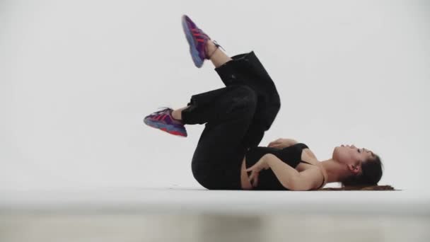 Baile - mujer joven con estilo libre bailando en el suelo sobre fondo blanco - Metraje, vídeo