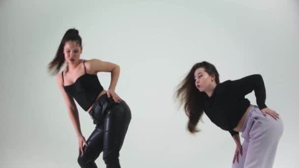 Dwie stylowe modelki tańczące na cykloramie - Materiał filmowy, wideo