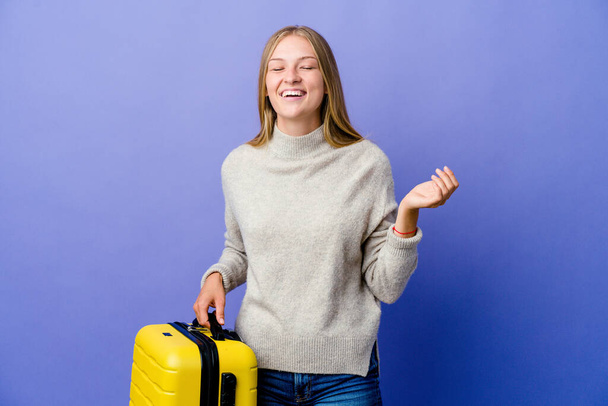 若いロシアの女性が喜んで多くの笑いを旅行するスーツケースを保持する。幸福の概念. - 写真・画像