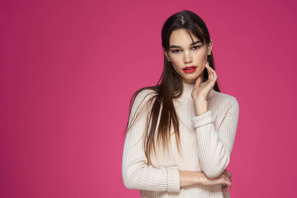 Brunette with long hair red lips cosmetics white sweater pink background cropped view - Fotografie, Obrázek