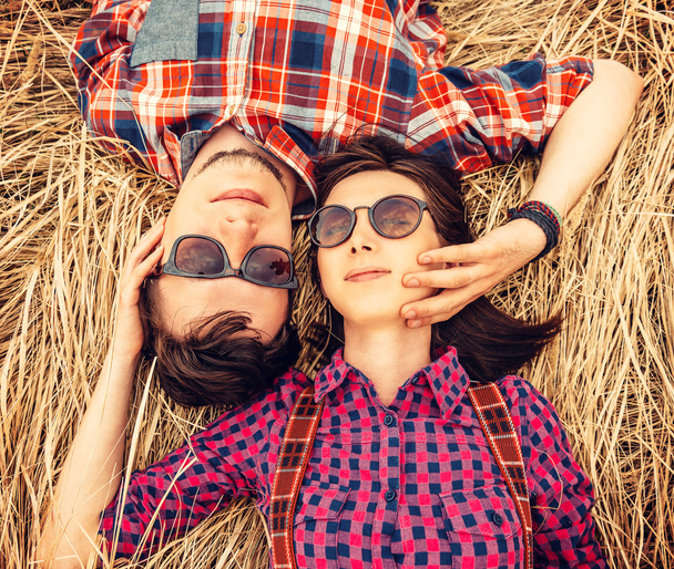 Couple in love is lying on the dry grass - Zdjęcie, obraz