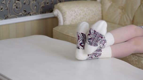 Naisten jalat kauniissa neulotut sukat pöydällä
 - Materiaali, video
