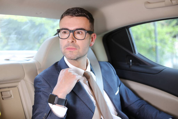 車の後部座席でハンサムな若いビジネスマンのクローズアップ肖像画 - 写真・画像
