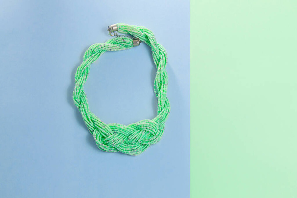 green necklace on green and blue background - Photo, Image