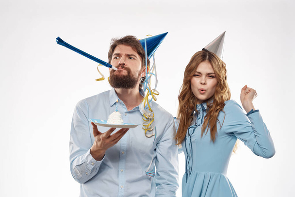 Férfi és nő sapkával a fejükön ünnepi és szórakoztató születésnapi meglepetés - Fotó, kép