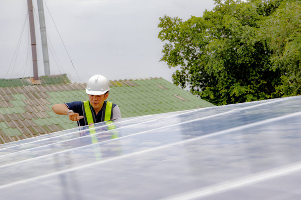 Mühendisler güneş panellerinin sıkılığını ve güvenliğini kontrol ederken, sanayi santralinin çatısına yeni yapılar kuruyorlar: Seçici Odaklanma - Fotoğraf, Görsel