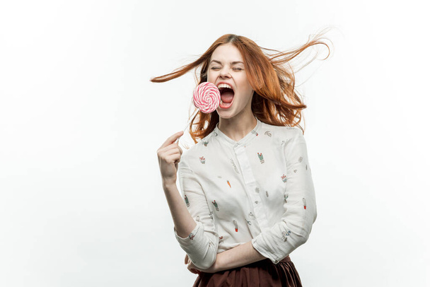 veselá zrzavá žena s lízátkem v rukou emoce otevírají ústa sladkosti - Fotografie, Obrázek