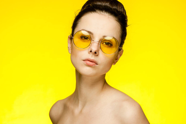 брюнетка с голыми плечами, желтые очки, чистая модель кожи - Фото, изображение