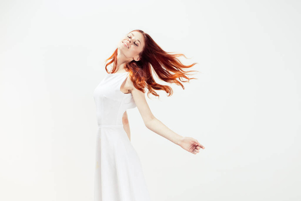 woman in white dress red hair glamor movement - Fotoğraf, Görsel