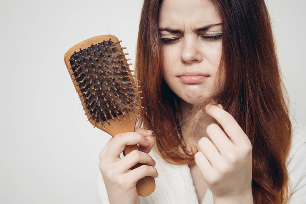 kobieta usuwa loki włosów z grzebienia utraty modelu problemów zdrowotnych - Zdjęcie, obraz