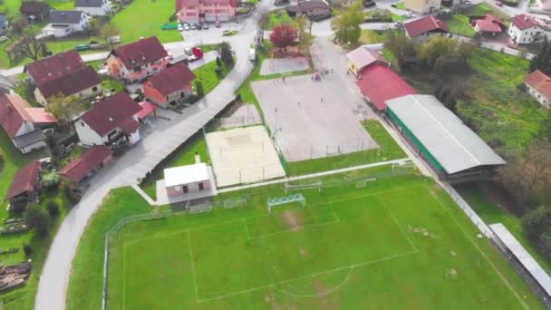 Légi parallax lövés egy iskolai játszótér és focipálya felett Domzale külvárosában - Felvétel, videó