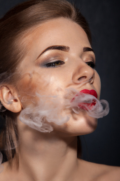 Beauty adult female smoking in studio - Foto, imagen