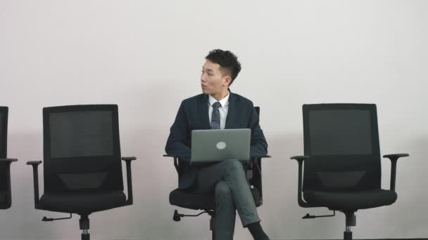 jovem asiático empresário trabalho candidato sentado no cadeira olhando para laptop computador esperando por sua vez para entrevista. - Filmagem, Vídeo