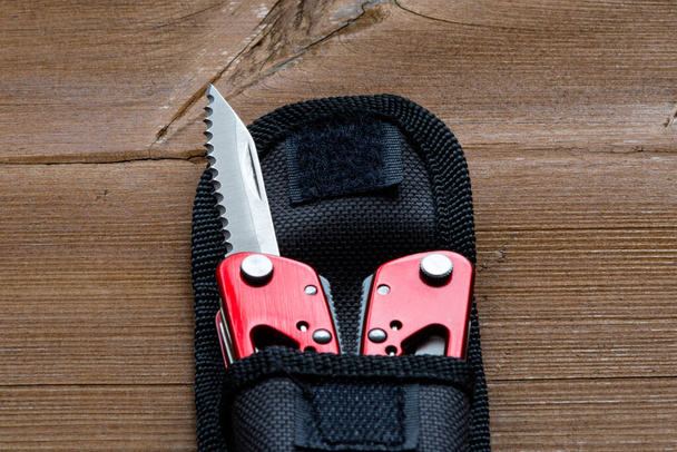 Multifunkční kapesní nůž s kapsou je umístěn na dřevěném stole - Fotografie, Obrázek
