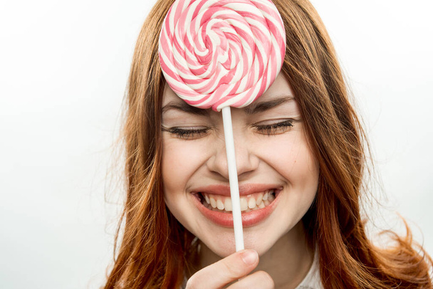 весела жінка з круглим льодяником в руках цукерки десерт радість
 - Фото, зображення