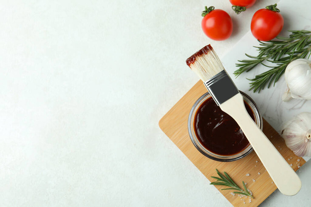 Концепція приготування з соусом з барбекю на білому фактурному столі
 - Фото, зображення