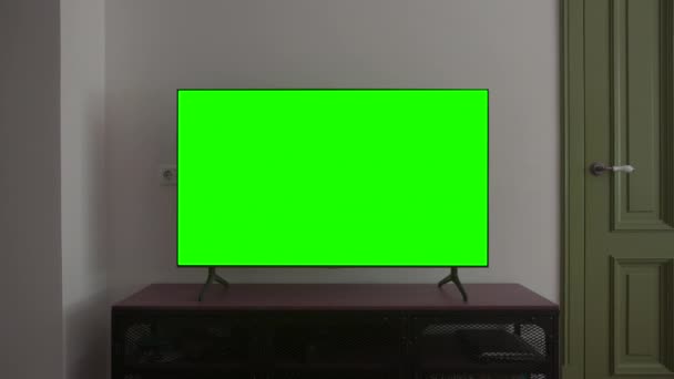 Телевизионный макет. Экран LSD Smart TV с бланкетным зеленым фоном в гостиной перед просмотром фильмов и видео в Интернете в 4К - Кадры, видео
