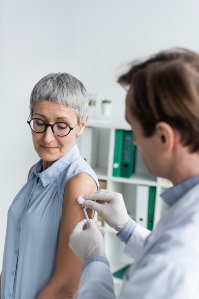 Patient mature debout près du médecin pendant la vaccination  - Photo, image
