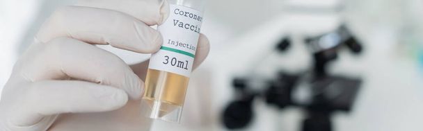 Vista cultivada do cientista em luva de látex segurando vacina coronavírus, bandeira  - Foto, Imagem