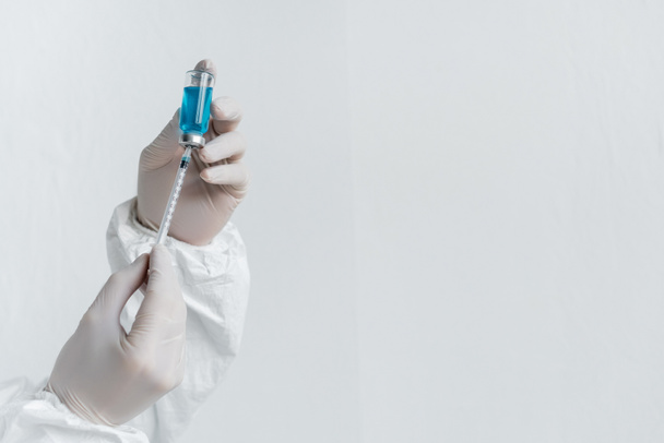 Vista recortada do cientista em luvas de látex segurando vacina e seringa  - Foto, Imagem