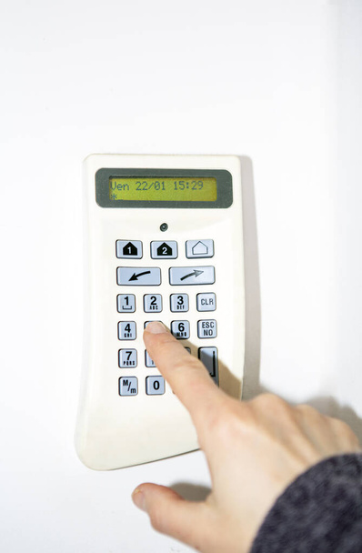 Sistema de alarma, mano de mujer introduciendo el código en el panel de seguridad para desbloquear la alarma - Foto, imagen
