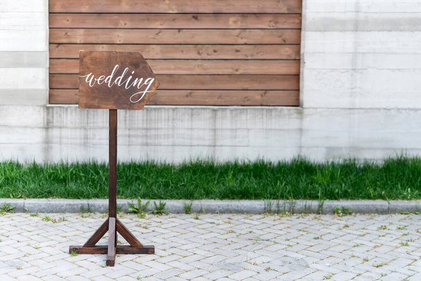 Wedding decor. Wooden plaque with the inscription in paint Wedding. Wood hand made signboard, welcome wedding decoration. - Photo, Image