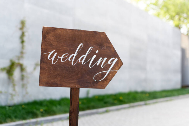Διακόσμηση γάμου. Ξύλινη πλάκα με την επιγραφή στο χρώμα Γάμος. Ξύλινη χειροποίητη πινακίδα, καλοδεχούμενη διακόσμηση γάμου. - Φωτογραφία, εικόνα