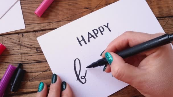 Tekst pisma ręcznego HAPPY BIRTHDAY na karcie papierowej - Materiał filmowy, wideo