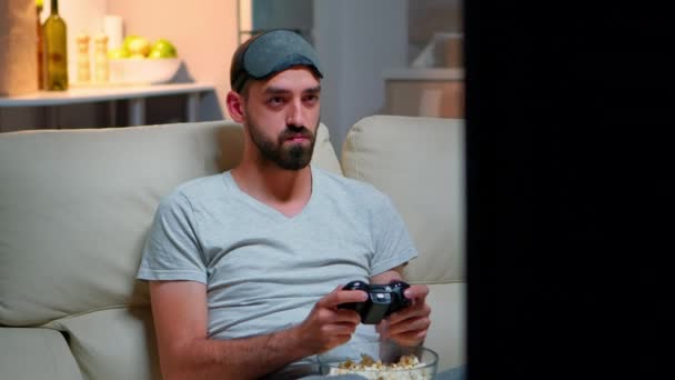 close-up van de man met oog slaap masker spelen videogames met joystick - Video