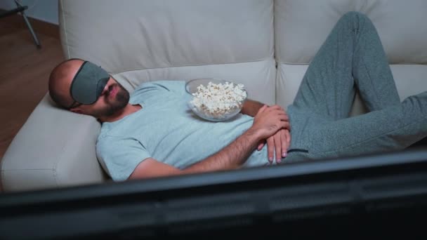 maschio caucasico addormentarsi mentre guarda film show seduto sul divano - Filmati, video
