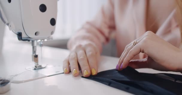 máquina de coser y las manos de un empleado de costura en el taller. Movimiento lento. - Metraje, vídeo
