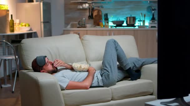 Homme couché sur le canapé, s'endormant devant la télé - Séquence, vidéo
