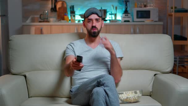 Homme adulte mangeant du pop-corn debout devant la télévision - Séquence, vidéo