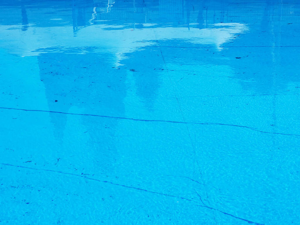 Acqua in una piscina blu con macchie e striature sul fondo. Foto a schermo intero - Foto, immagini