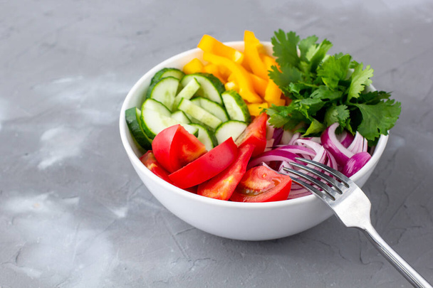 Tányér szivárvány saláta különböző zöldségek és gyógynövények fehér tál villával szürke kő háttér - Fotó, kép